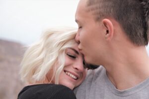 pareja de novios, él besando la frente de ella