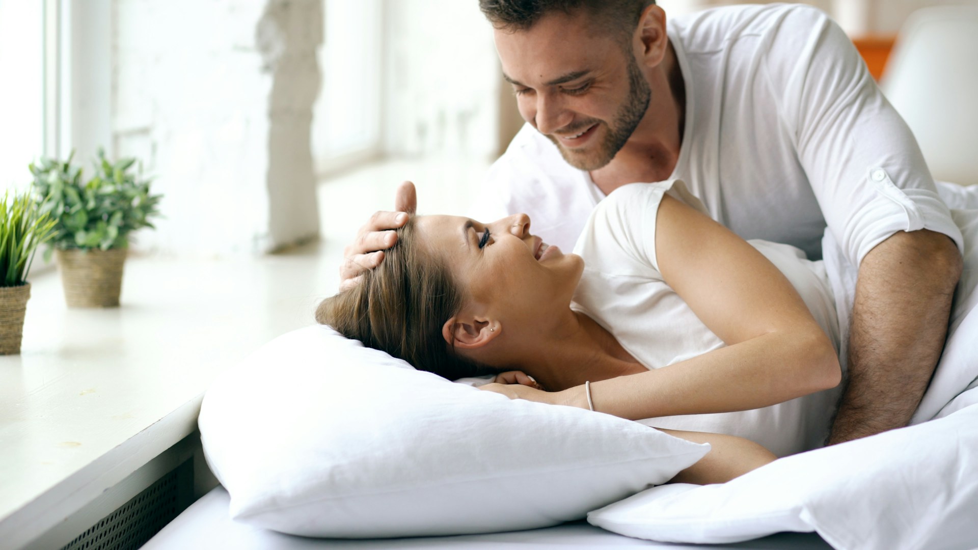 Pareja despertando en su habitación en la mañana