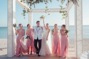 Novios y damas de honor en la boda en la playa