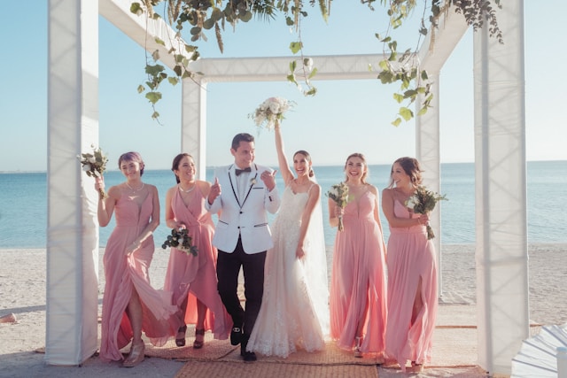 Novios y damas de honor en la boda en la playa