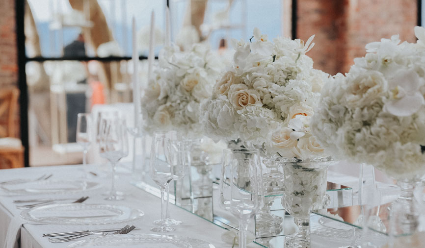 Mesas rectangulares para boda decoradas con manteles y flores